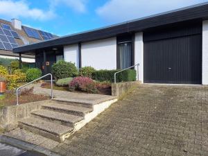 a house with stairs leading to a garage at Hill Star in Mönchengladbach