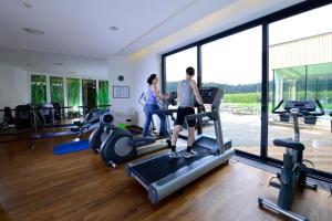 茲韋特爾的住宿－施瓦茨阿爾姆酒店，两人在健身房跑步机上
