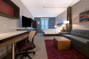 a hotel room with a bed and a desk and a couch at Home2 Suites By Hilton Redding in Redding