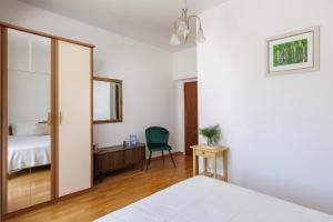 a bedroom with a bed and a desk and a chair at Villa Misita Elegant SeaView Rooms in Dubrovnik