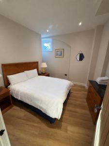 a bedroom with a white bed and a window at Windsor Flat 90C in Windsor +8 photos
