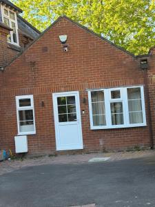 a brick building with a white door and windows at Windsor Flat 90C in Windsor