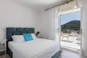 a bedroom with a large bed and a balcony at Villa Misita Elegant SeaView Rooms in Dubrovnik +44 photos