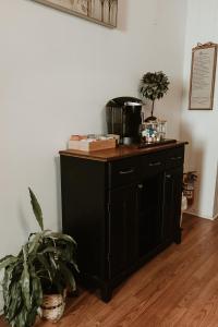 a black cabinet with a coffee maker and a plant at Strassner Suites - Imy Suite in Hermann +9 photos