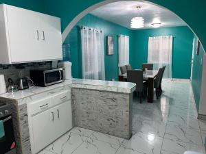 a kitchen with white cabinets and a dining room at Blue Paradise in Coxen Hole