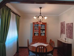 a dining room with a table and a china cabinet at Apart. Av. António Feijó in Ponte de Lima
