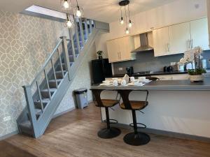 a kitchen with a table with two chairs and a staircase at Snuggle Inn Burnley in Burnley