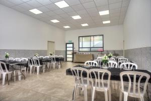 a dining room with tables and white chairs at אחוזת בין ההרים צפת in Safed