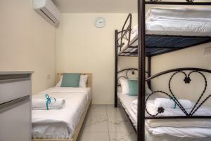 a room with two bunk beds with white sheets at אחוזת בין ההרים צפת in Safed