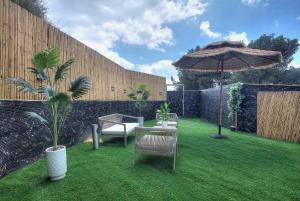 a patio with an umbrella and two chairs and a table and an umbrella at אחוזת בין ההרים צפת in Safed