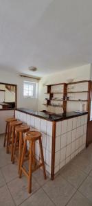 a kitchen with wooden stools and a counter top at Apartmani Fico II in Sveti Stefan +6 photos