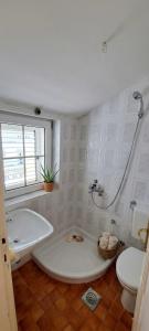 a white bathroom with a tub and a toilet at Apartmani Fico II in Sveti Stefan