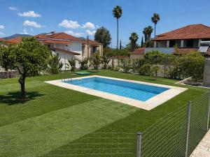 a yard with a swimming pool and a fence at Casa Plati 1 - Modern Escape with Pool & Garden in Platí