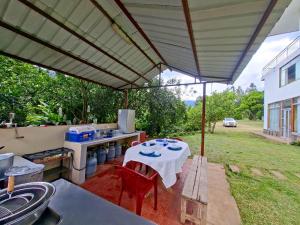 an outdoor kitchen with a table and chairs under a canopy at Hotel Paraíso in San Antonio +1 photo