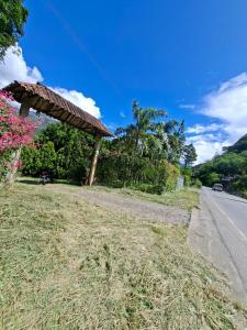 a grass field next to a road with a building at Hotel Paraíso in San Antonio