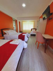 a hotel room with two beds and a desk at Hotel Paraíso in San Antonio
