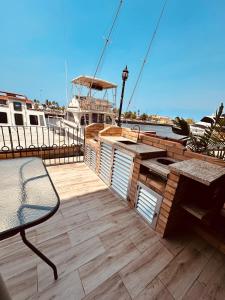 a wooden deck with a table and a boat at Villa Corfus in Barrio El Paraíso