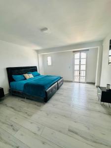 a large bedroom with a bed and a wooden floor at Villa Corfus in Barrio El Paraíso