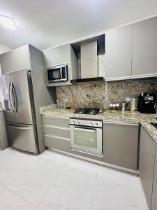 a kitchen with stainless steel appliances and white cabinets at Villa Corfus in Barrio El Paraíso