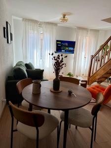a living room with a table and chairs and a couch at Le charmant Duplex de la Bibliothèque - Vélos Friendly- Centre historique et proche Europa-Park in Sélestat
