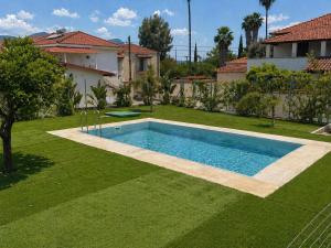 a swimming pool in a yard next to a house at Casa Plati 2 - Peaceful Garden Stay with Pool in Platí
