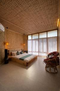 a bedroom with a large bed and a chair at Chader Bari Beach Resort, Cox's Bazar in Cox's Bazar