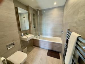 a bathroom with a tub and a toilet and a sink at Stunning 2Bedrooms, 2Baths, Balcony, Parking in Colindale