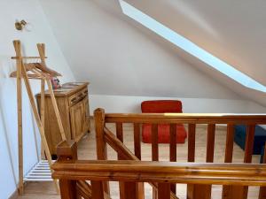 a room with a staircase with a chair and a table at Le charmant Duplex de la Bibliothèque - Vélos Friendly- Centre historique et proche Europa-Park in Sélestat