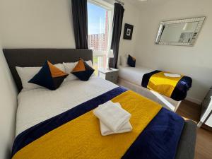 a bedroom with two beds with yellow and blue at Stunning 2Bedrooms, 2Baths, Balcony, Parking in Colindale +27 photos