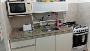 a small kitchen with a sink and a microwave at Duplex parque in Santiago del Estero