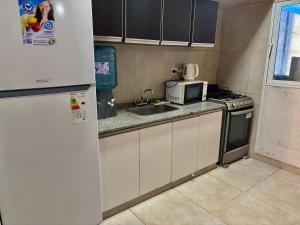 a small kitchen with a sink and a microwave at Duplex parque in Santiago del Estero