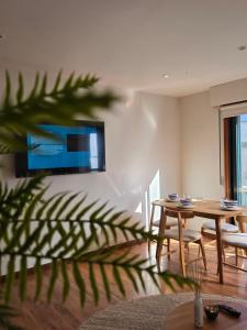 a living room with a table and a tv on the wall at Celta Home in Vigo