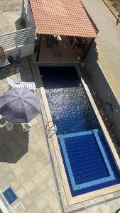 an overhead view of a swimming pool with an umbrella at Pequeno Paraíso Flats Praia Bela in Pitimbu