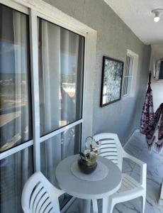 a white table and chairs on a porch with a table and chairs at Pequeno Paraíso Flats Praia Bela in Pitimbu