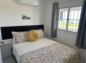 a bedroom with a bed with a large window at Pequeno Paraíso Flats Praia Bela in Pitimbu