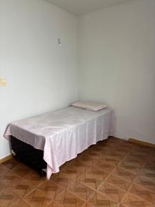 a bed in a corner of a room at Aluga-se Casa Espaçosa - 2 Quartos in São Luís