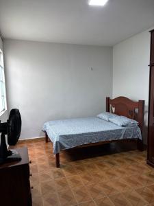 a bedroom with a bed in the corner of a room at Aluga-se Casa Espaçosa - 2 Quartos in São Luís