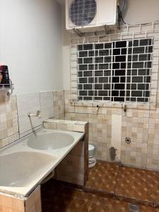 a bathroom with a large sink and a window at Aluga-se Casa Espaçosa - 2 Quartos in São Luís