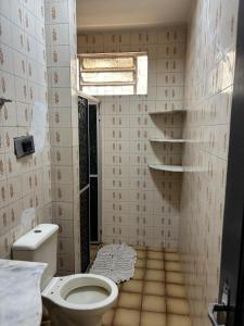 a small bathroom with a toilet and a window at Aluga-se Casa Espaçosa - 2 Quartos in São Luís