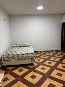 a bedroom with a bed in the corner of a room at Aluga-se Casa Espaçosa - 2 Quartos in São Luís