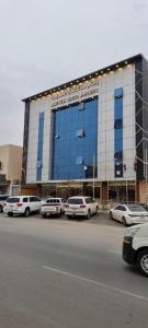 a large building with cars parked in a parking lot at راحتي هنا in Riyadh