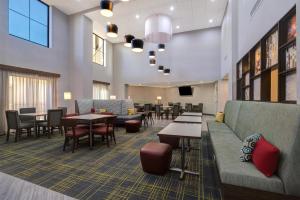 a waiting room with tables and chairs and a couch at Hampton Inn & Suites Marina in Marina