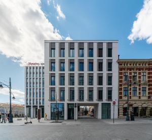 a large white building on a city street at Hampton by Hilton Łódź City Center in Łódź +41 photos