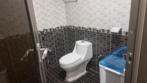 a bathroom with a toilet and a tiled floor at راحتي هنا in Riyadh