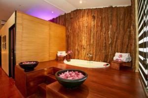 a bathroom with a tub and a large wooden wall at Ekho Safari Tissa in Tissamaharama