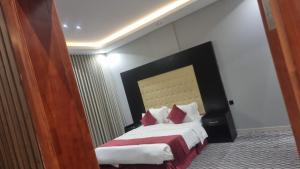 a hotel room with a bed with red pillows at راحتي هنا in Riyadh +7 photos