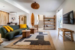 a living room with a green couch and a rug at Outsite Ibiza - Work, Connect, Explore in Es Cana