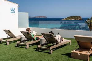 two people sitting in lawn chairs on a balcony at Outsite Ibiza - Work, Connect, Explore in Es Cana