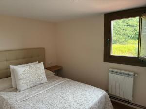 a bedroom with a bed with a pillow and a window at Casa Os Lindeiros in Arzúa +19 photos