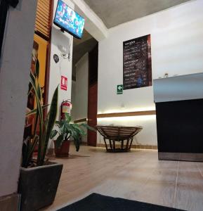 a waiting room with a table and a sign on the wall at Hospedaje SAUNA & SPA NOAH in Bagua Grande